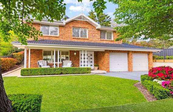 Two-storey red-brick front of 52 Shortland Street, with a verandah, double garage and lawn